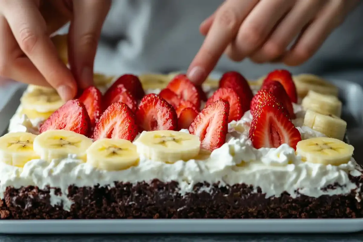 Close-up of strawberries being layered on dessert pizza